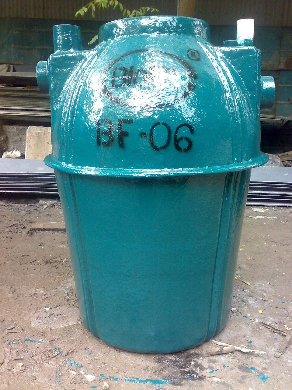 Teal fiberglass septic tank standing upright on dirt ground (sample photo)